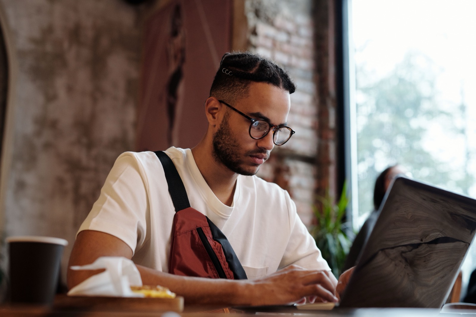 A freelancer working on a laptop in a café