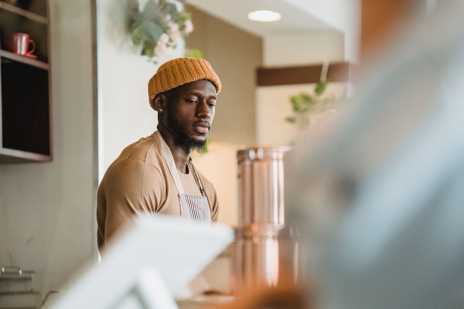 A café owner in an apron working behind the counter