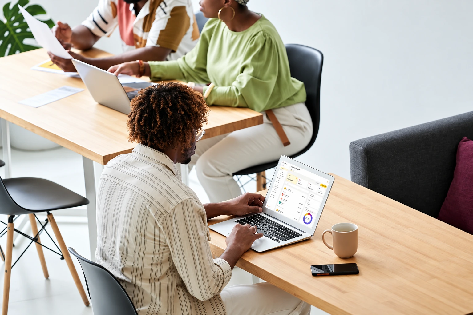 A startup team working together, one reviewing the Nomba dashboard on a laptop