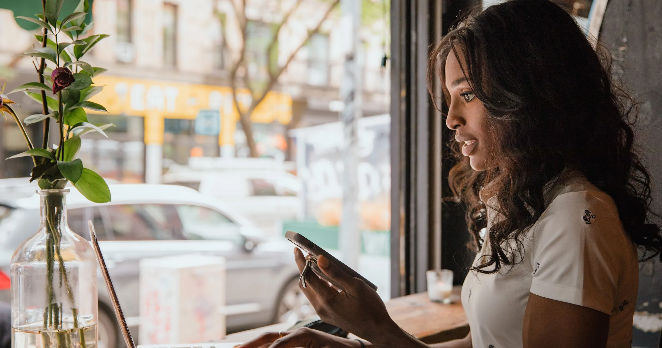 Business owner reviewing an international transfer on her phone in a cafe